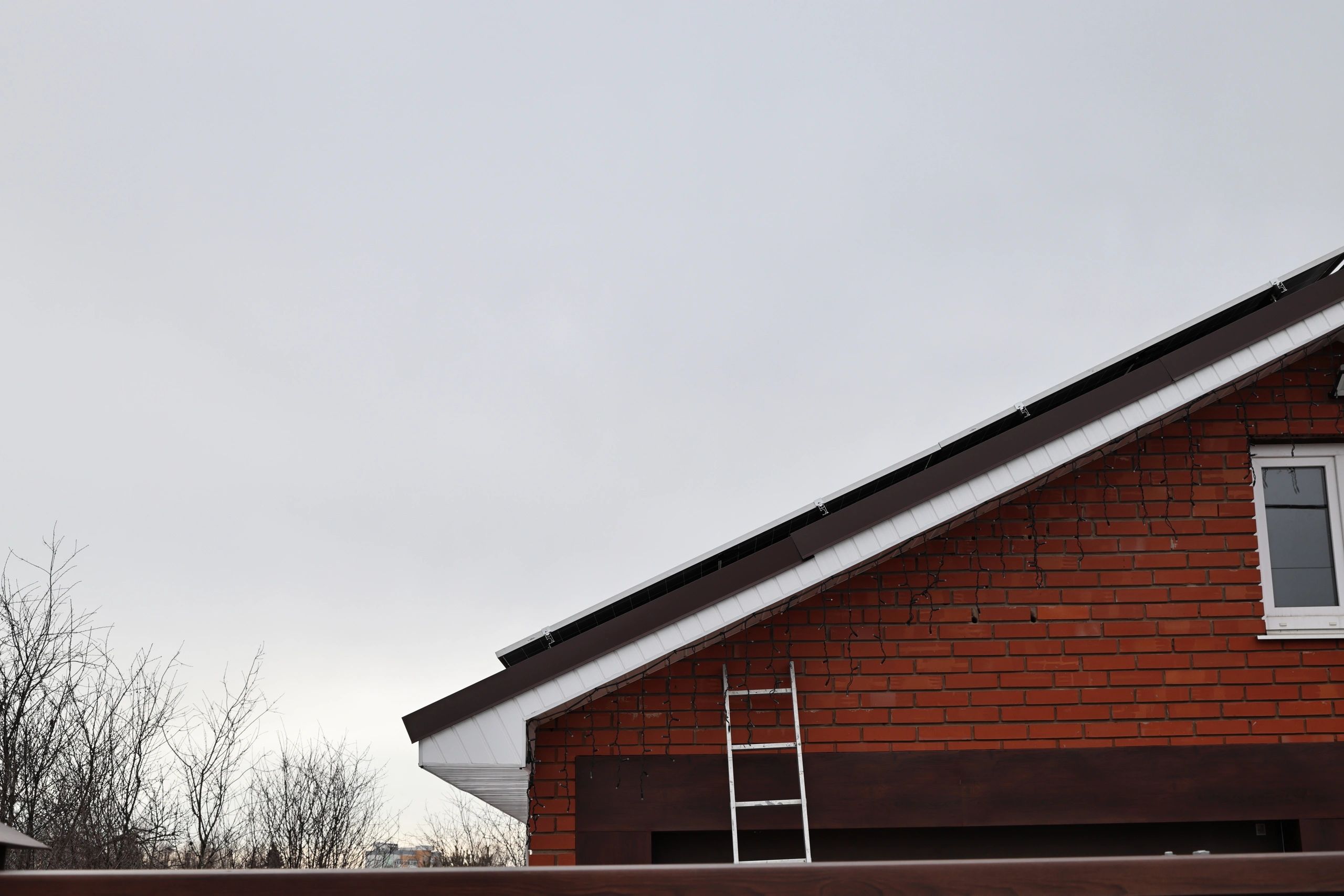 Ladder set against a residential roof for inspection